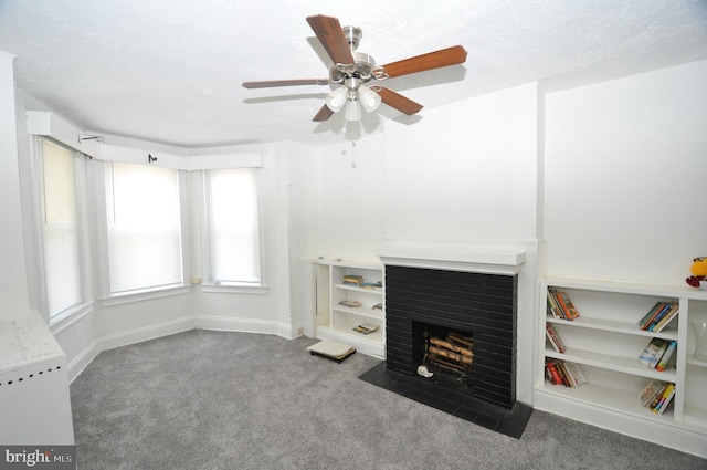 unfurnished living room with ceiling fan, carpet, a textured ceiling, and a brick fireplace