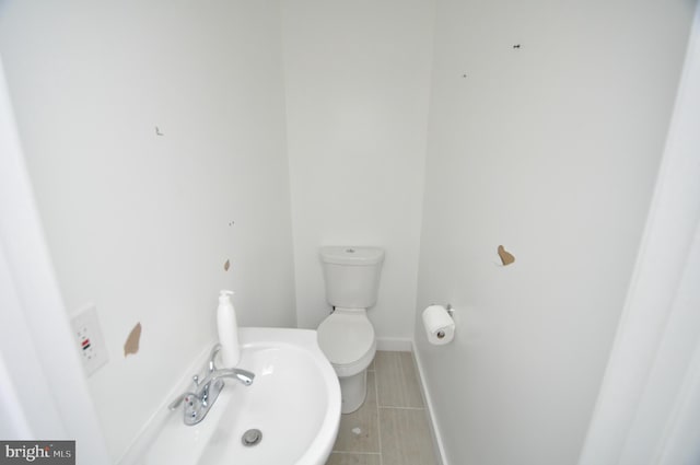 bathroom with sink, toilet, and tile patterned floors