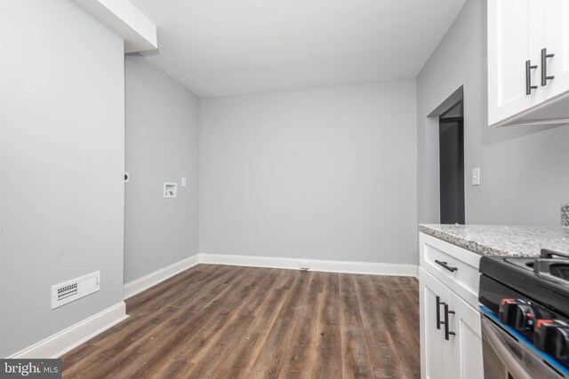 kitchen featuring white cabinets, stove, and dark hardwood / wood-style flooring