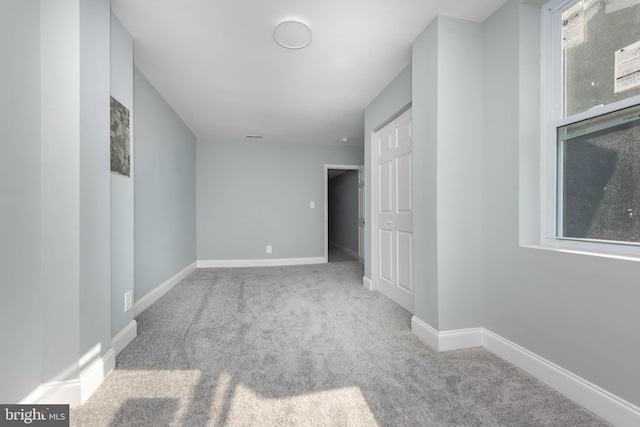 unfurnished room featuring light colored carpet and a healthy amount of sunlight