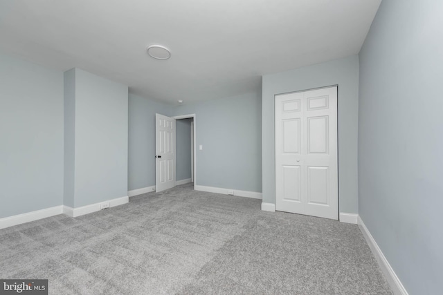 unfurnished bedroom featuring light colored carpet and a closet