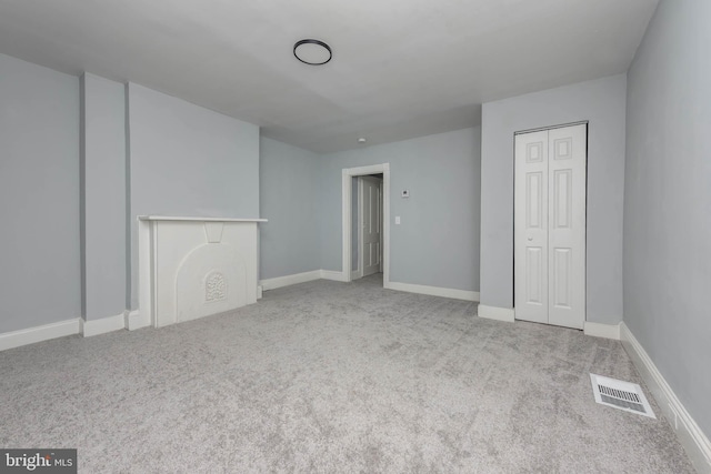 unfurnished bedroom with light carpet and a closet