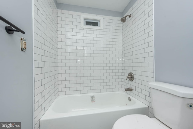 bathroom featuring toilet and tiled shower / bath