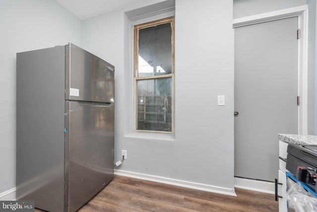 kitchen with stove, dark hardwood / wood-style floors, and stainless steel fridge