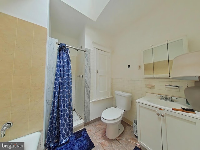 bathroom with toilet, curtained shower, tile patterned flooring, vanity, and tile walls