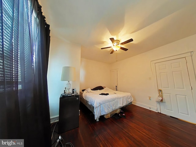 bedroom with baseboards, dark wood finished floors, and a ceiling fan