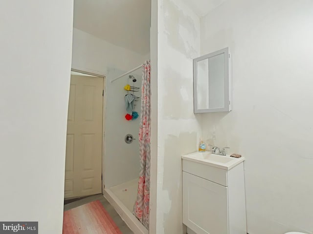 bathroom with a shower stall and vanity