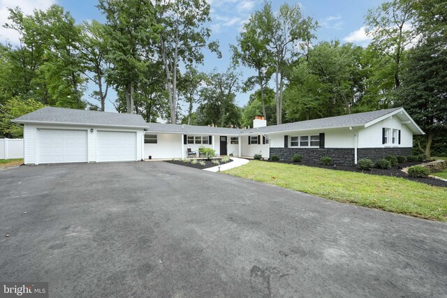 ranch-style house with a garage and a front yard