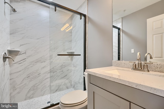 bathroom with a shower with door, toilet, and vanity