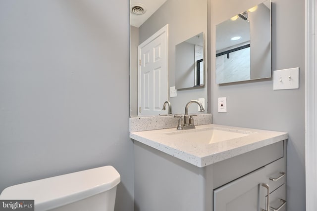 bathroom featuring toilet and vanity