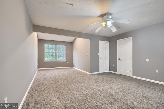 unfurnished room featuring ceiling fan, carpet, and a textured ceiling