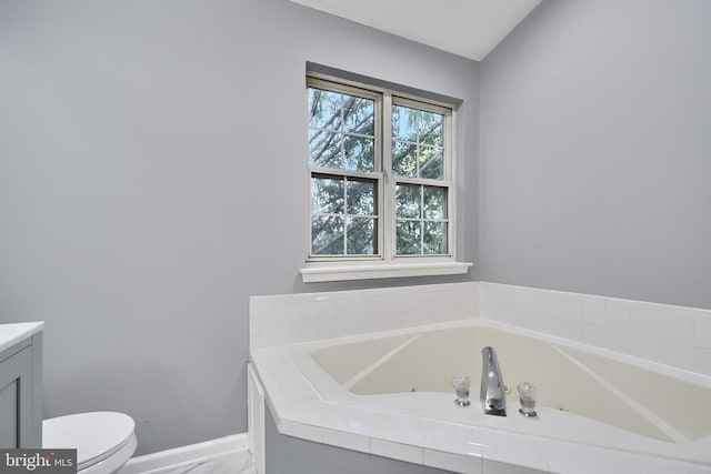 bathroom featuring a tub, vanity, and toilet