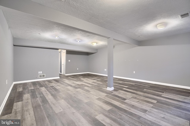 basement with a textured ceiling and hardwood / wood-style flooring