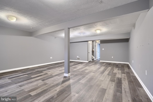 basement with hardwood / wood-style flooring and a textured ceiling