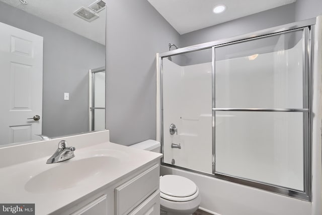 full bathroom with combined bath / shower with glass door, toilet, and vanity