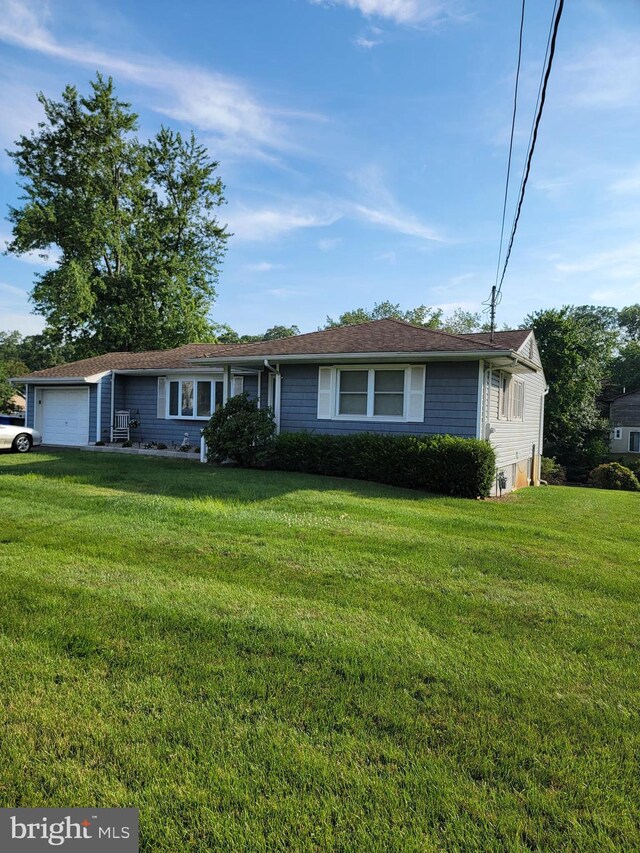 single story home with a garage and a front yard