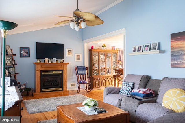 living room featuring hardwood / wood-style flooring, ceiling fan, vaulted ceiling, and ornamental molding