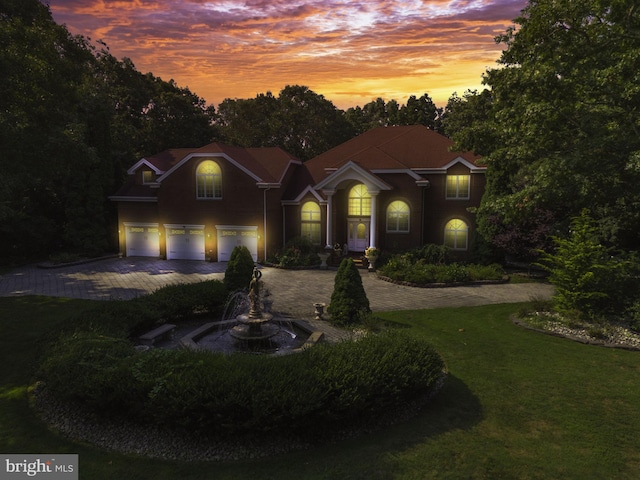 view of front of property featuring a garage and a yard