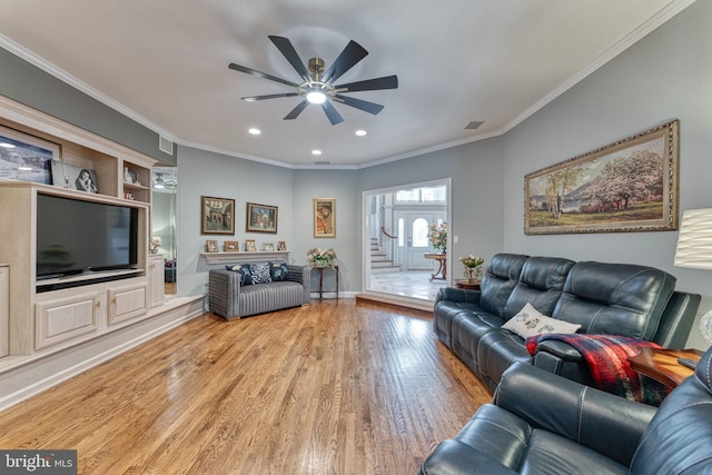 living room with wood-type flooring, crown molding, and ceiling fan