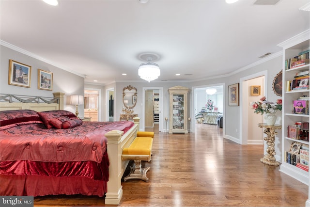 bedroom with ornamental molding and hardwood / wood-style floors