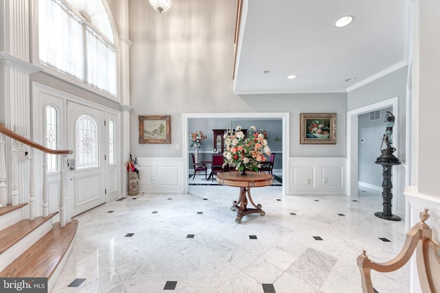 entrance foyer with a high ceiling and ornamental molding