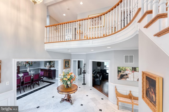 living room featuring ornamental molding, a towering ceiling, and hardwood / wood-style floors