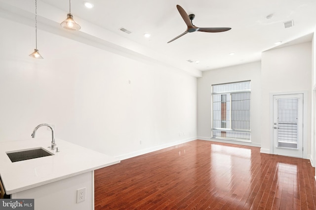 unfurnished living room featuring sink, hardwood / wood-style floors, and ceiling fan