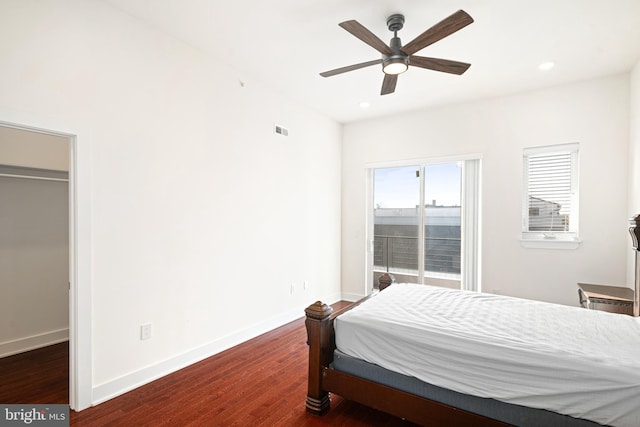 bedroom with dark wood-type flooring, ceiling fan, a closet, and a spacious closet