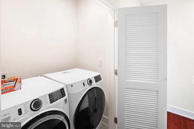 laundry area with separate washer and dryer and dark hardwood / wood-style floors