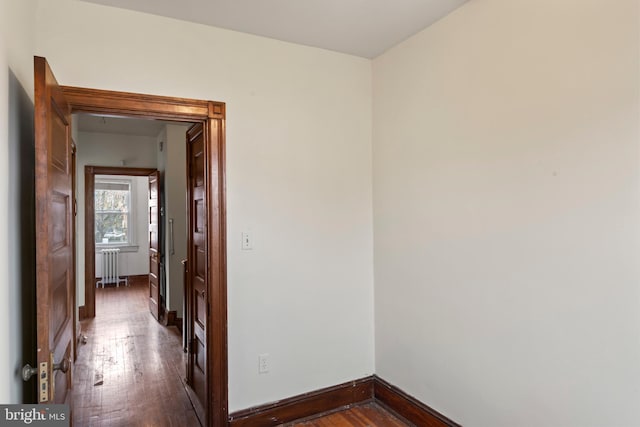 corridor with radiator and dark hardwood / wood-style floors