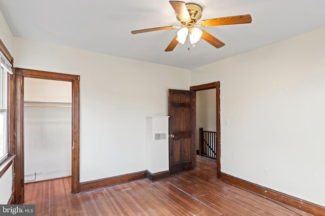 unfurnished bedroom with ceiling fan, wood-type flooring, and a closet