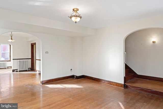 spare room with radiator and hardwood / wood-style floors