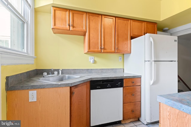 kitchen featuring white appliances, sink, and light tile patterned floors