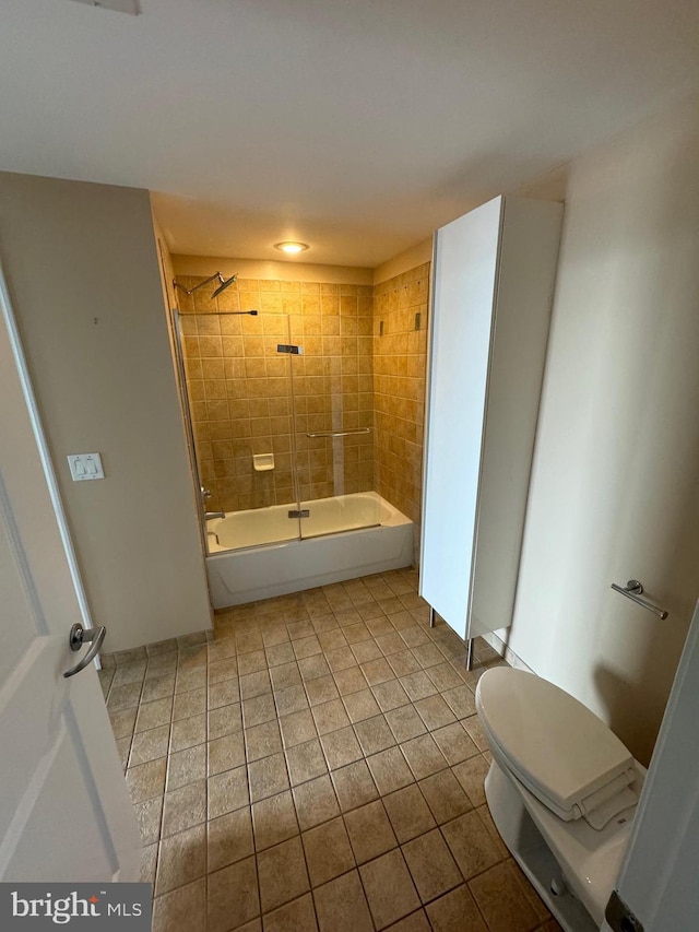 bathroom with tile patterned floors, toilet, and tiled shower / bath