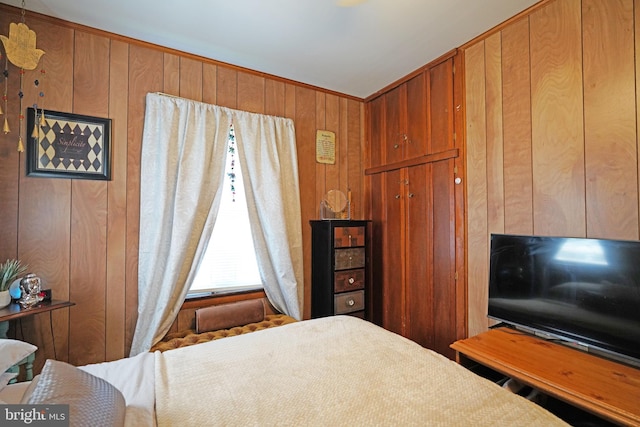 bedroom featuring wooden walls