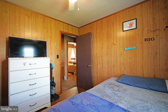 bedroom featuring wood walls and ceiling fan