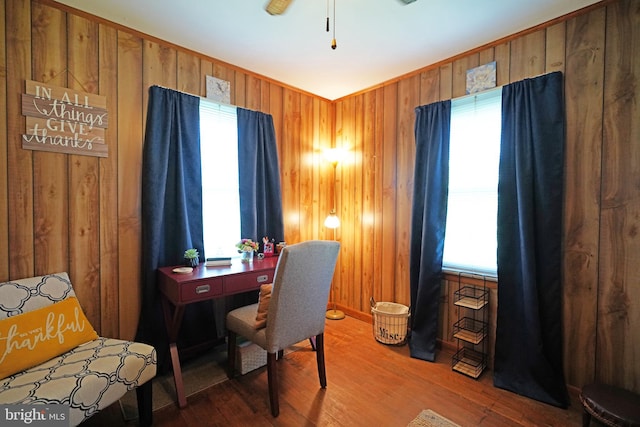 office area with hardwood / wood-style flooring, wooden walls, and a healthy amount of sunlight