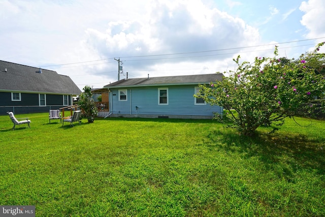 rear view of property featuring central AC, a yard, and a deck