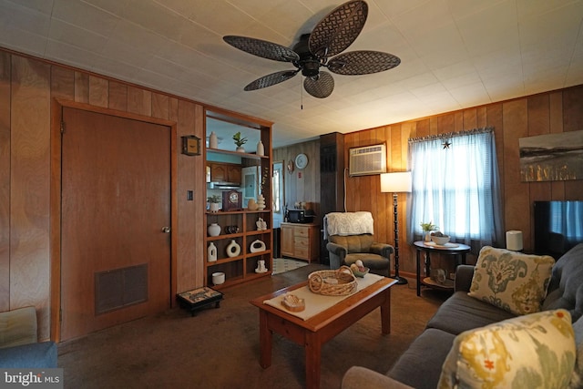 carpeted living area featuring a wall unit AC, wooden walls, visible vents, and a ceiling fan