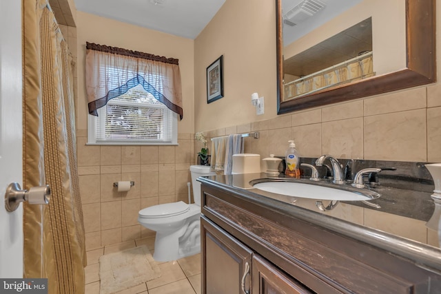 bathroom with tile patterned flooring, visible vents, tile walls, toilet, and vanity