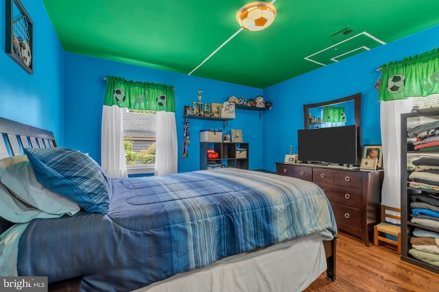 bedroom featuring visible vents and wood finished floors