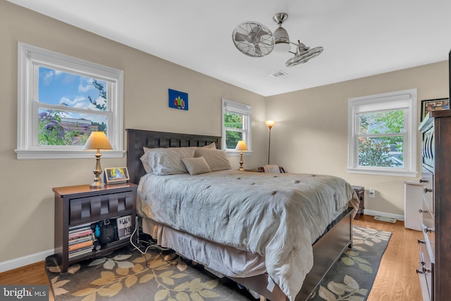 bedroom featuring visible vents, baseboards, and wood finished floors