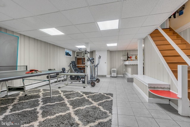 exercise room featuring tile patterned flooring and a paneled ceiling