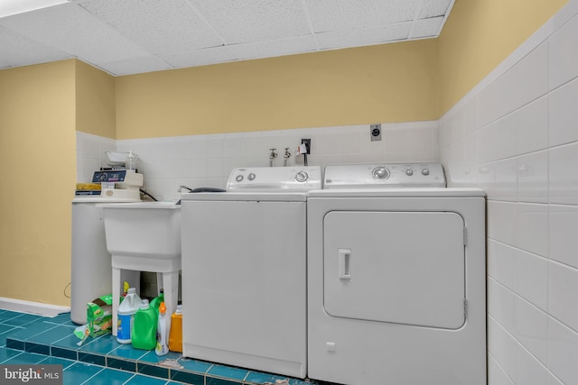 laundry room featuring laundry area, washing machine and dryer, and tile walls