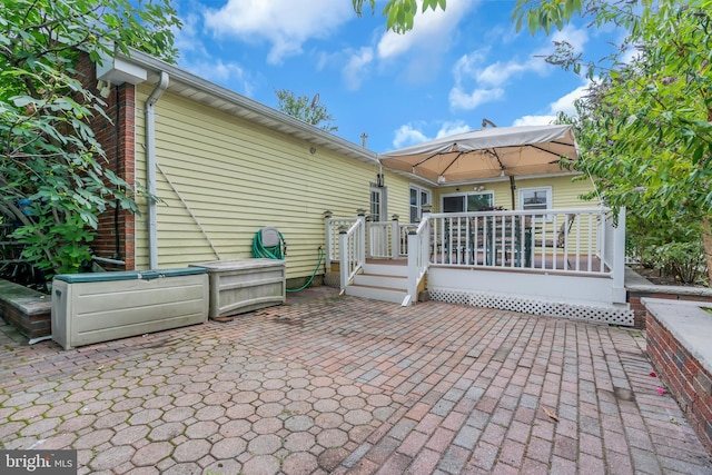 rear view of property featuring a deck and a patio area