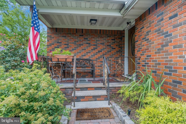 view of exterior entry featuring brick siding