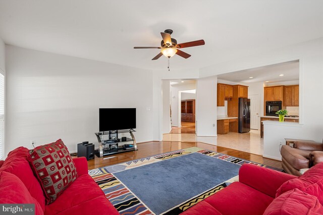 living room with ceiling fan and light hardwood / wood-style floors