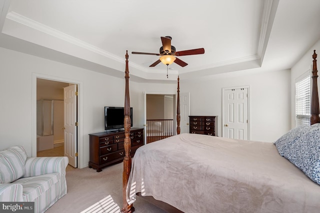 bedroom with crown molding, a raised ceiling, and light colored carpet