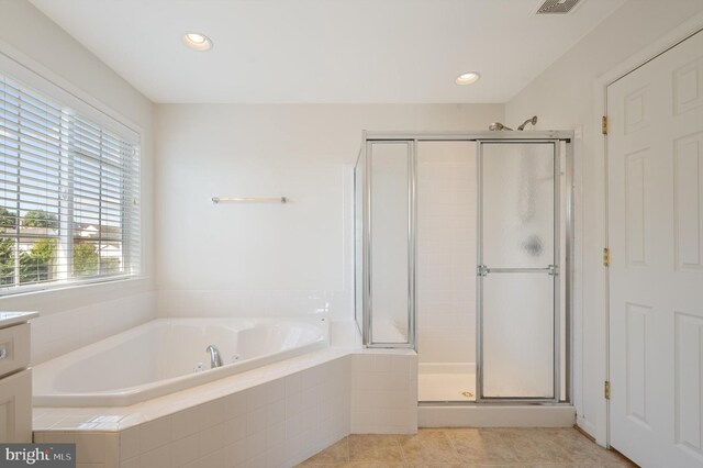 bathroom featuring independent shower and bath, vanity, and tile patterned floors