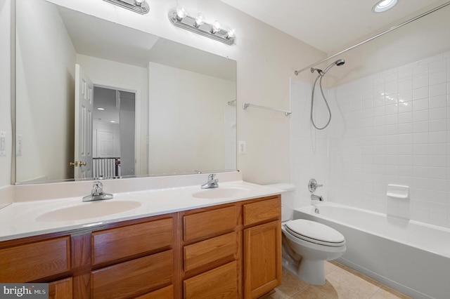 full bath with  shower combination, a sink, toilet, and tile patterned floors